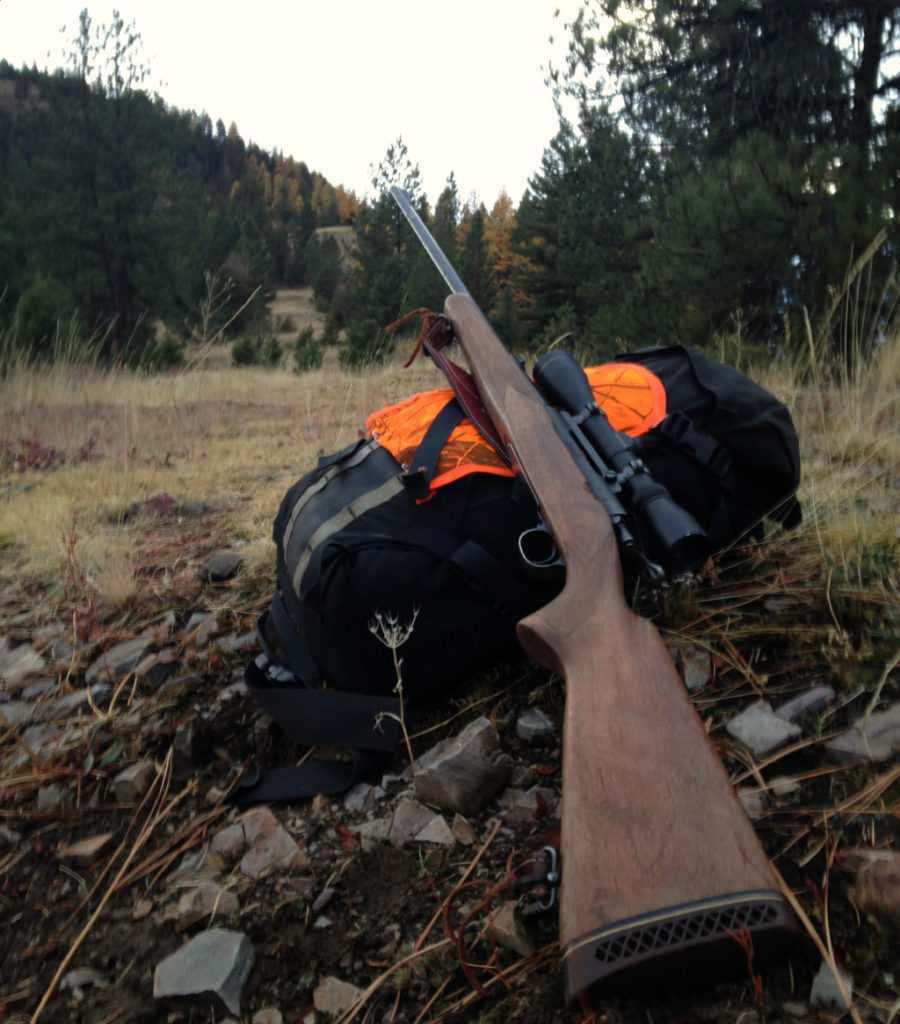 Our trusty Winchester rifle laying across a backpack.